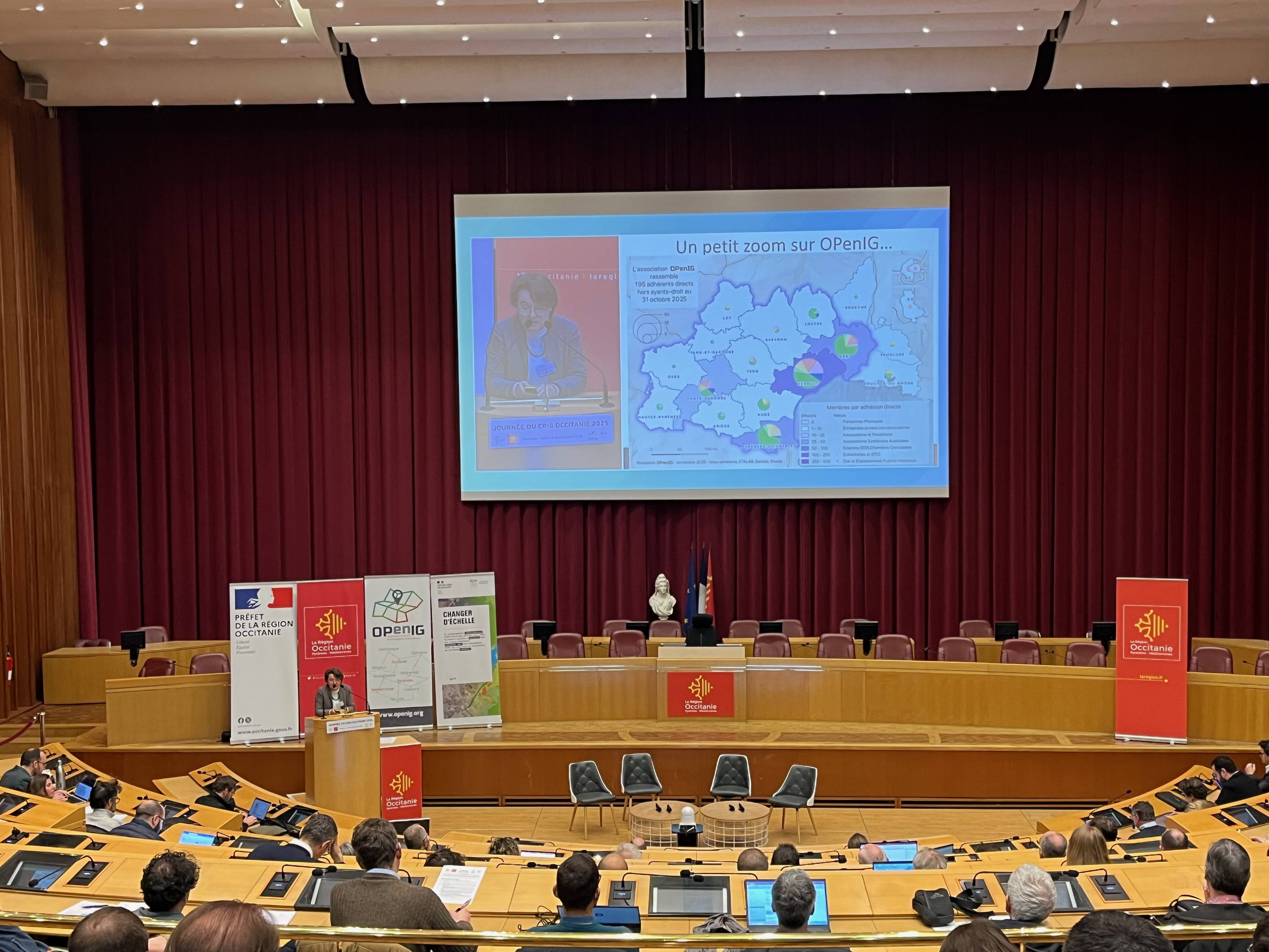 Présentation de la journée CRIG dans la salle de l'assemblée au Conseil Régional de Toulouse. Anne Fromage-Mariette, directrice d'OPenIG, introduit le programme de la journée et fait le point sur les actualités.